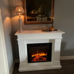 Moderne woonkamer met Dimplex Firebox XHD28 elektrische haard en rechte schouw ombouw van MDF voor extra warmte en sfeer.